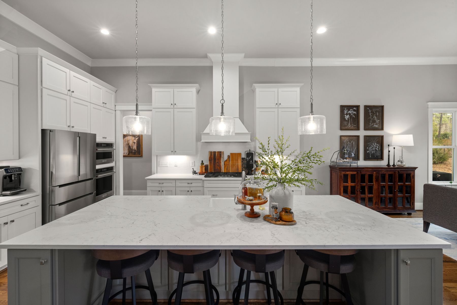 Large white kitchen with an island and pendant lights